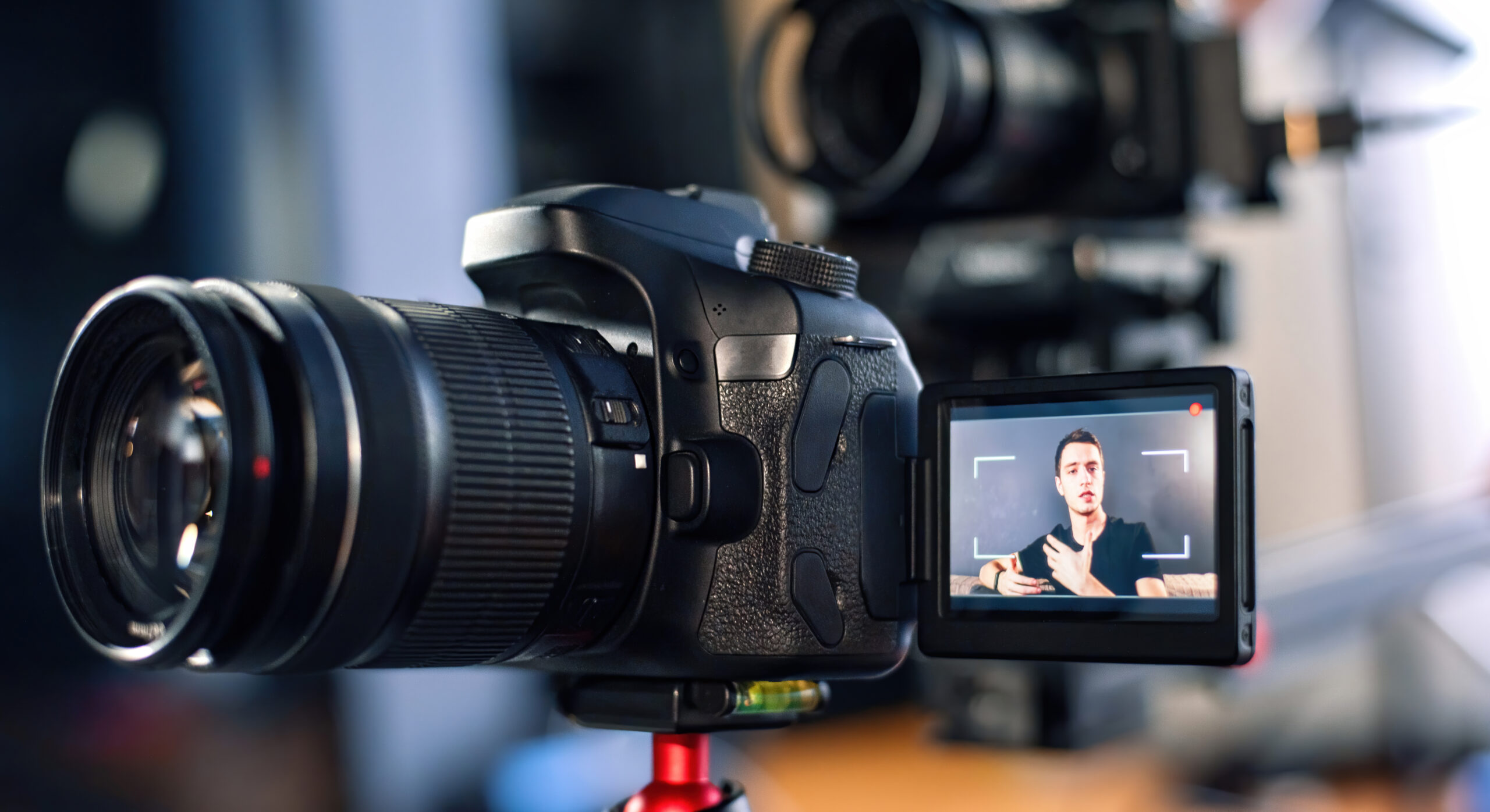 Man talking at the camera, recording himself in a vlog. Working from home. Young content creator. Multiple cameras